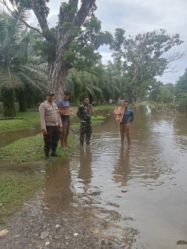 Bhabinkamtibmas Polsek Hinai Bersama Perangkat Desa Tamaran dan Babinsa Koramil Salurkan Bantuan kepada Warga Terdampak Banjir