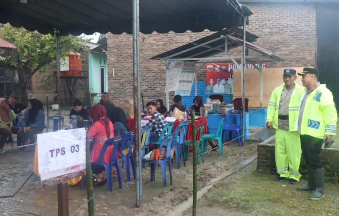 Diguyur Hujan, Kapolresta Deli Serdang Tinjau Langsung Pelaksanaan Pemungutan Suara di TPS